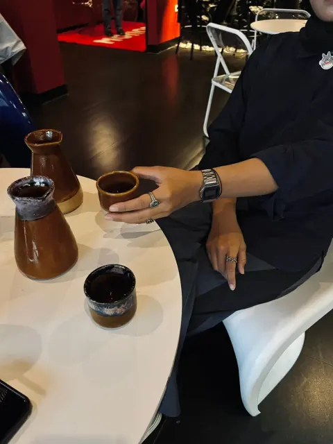 Kaffeeaufguss von Hand neben Kännchen und Tasse.