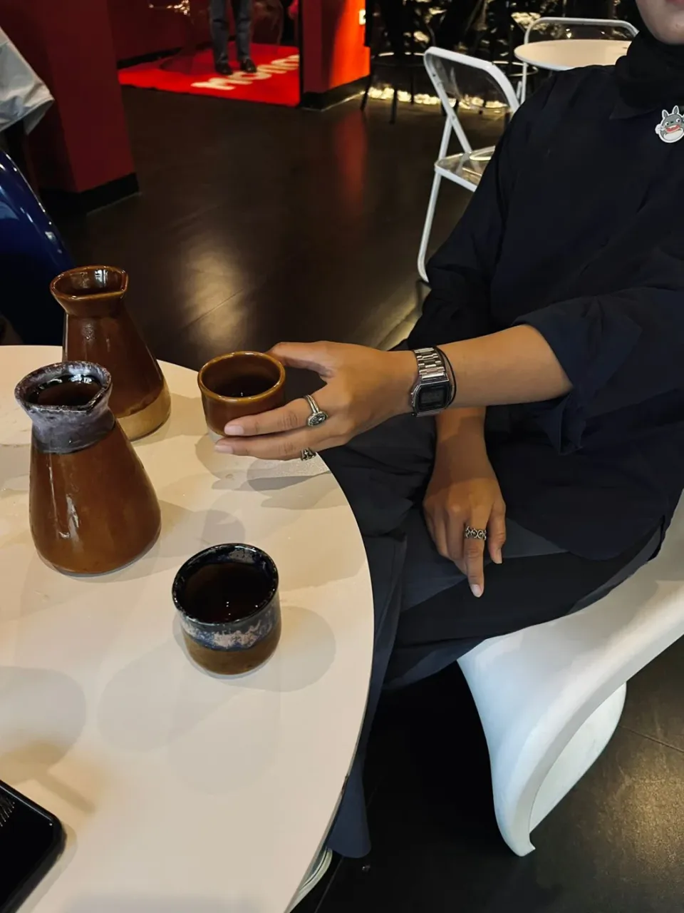 Kaffeeaufguss von Hand neben Kännchen und Tasse.