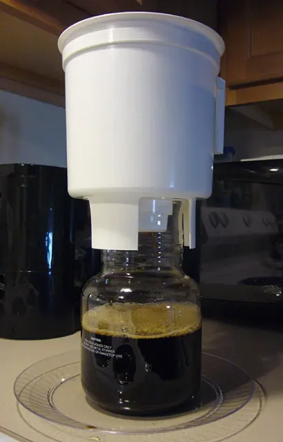 Toddy-Cold-Brew-System mit weißem Brühbehälter über einer Glaskaraffe.