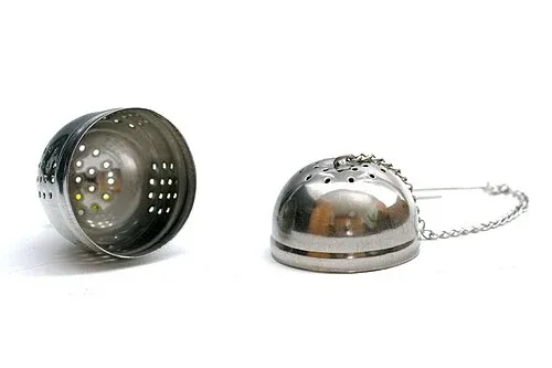 Geöffnetes zweiteiliges Tee-Ei aus gelochtem Metall mit Kette.