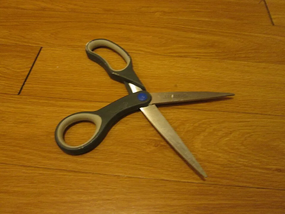 Tijeras de uso diario abiertas sobre una mesa.