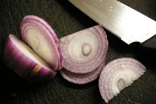 Cebolla cortada con un cuchillo.