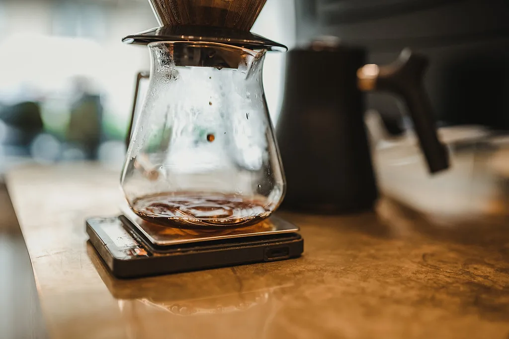 Café goteando en una jarra de vidrio sobre una báscula.