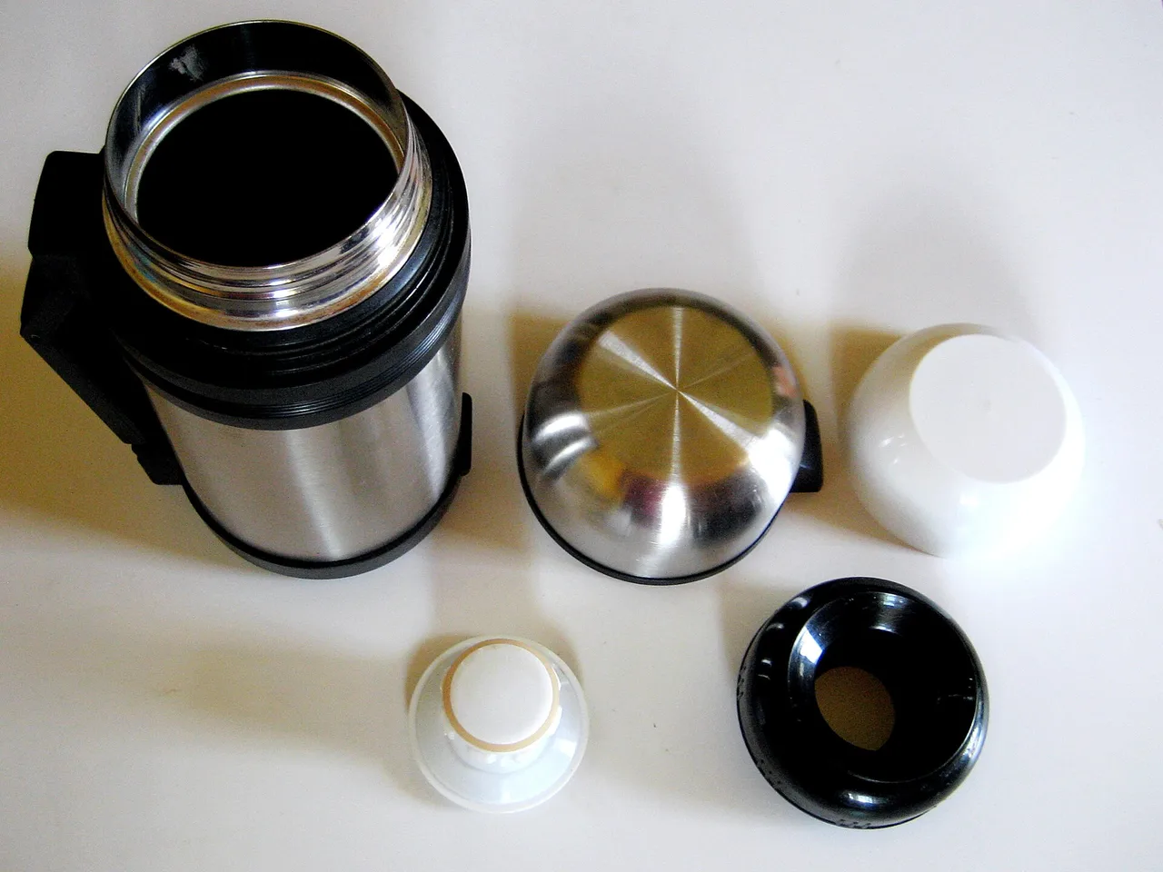 Termo de acero abierto, con tapones y vasos separados.