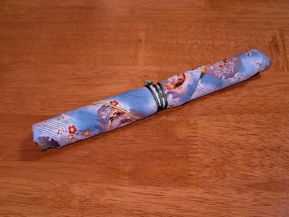 Palillos de viaje guardados en una funda de tela enrollada.