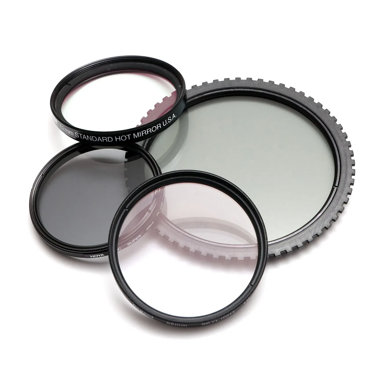Cuatro filtros fotográficos circulares sobre fondo blanco.