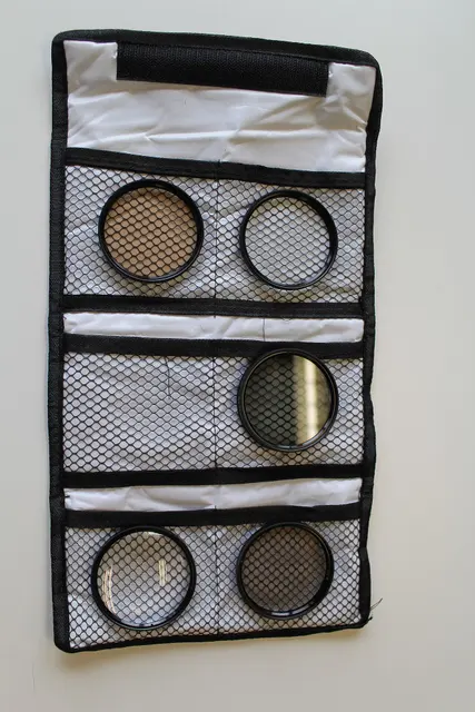 Estuche abierto con filtros Opteka de 58 mm. Imagen ilustrativa para guardar filtros; no corresponde al kit de la selección.