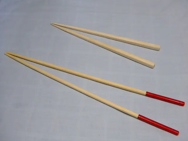 Palillos largos de cocina saibashi junto a palillos más cortos para comer.