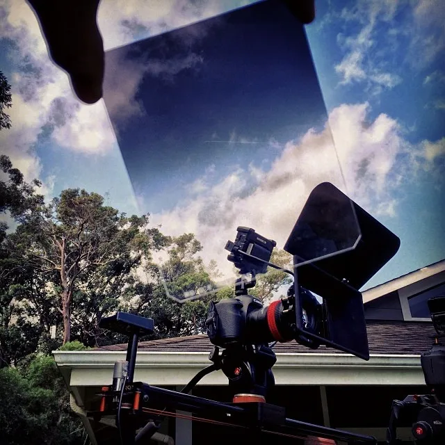 Filtre dégradé rectangulaire Formatt-Hitech tenu devant le ciel.