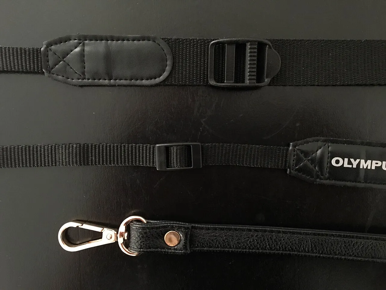 Trois systèmes d’attache de sangles photo en tissu et en cuir