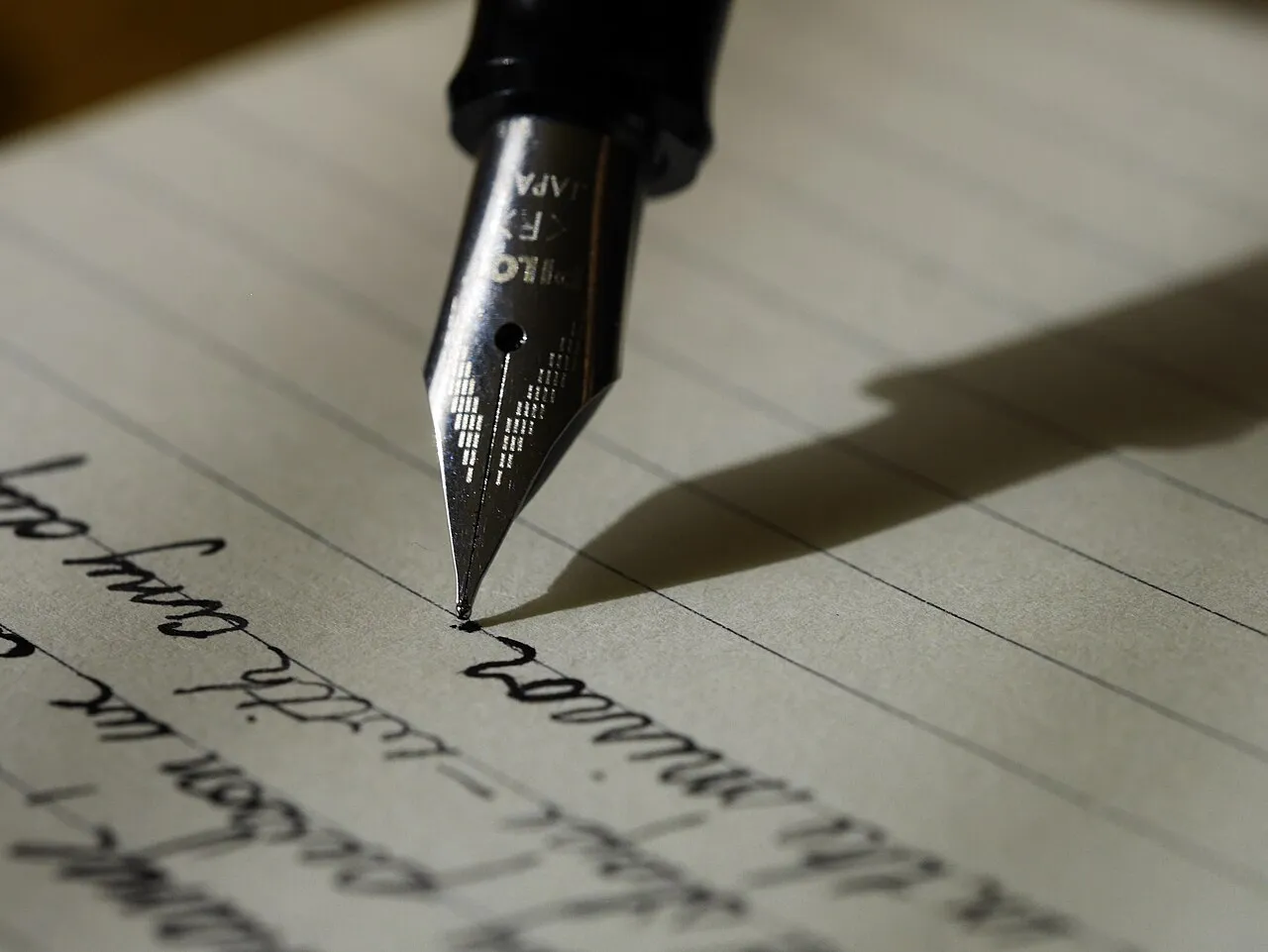 Plume d’un stylo écrivant sur une page lignée