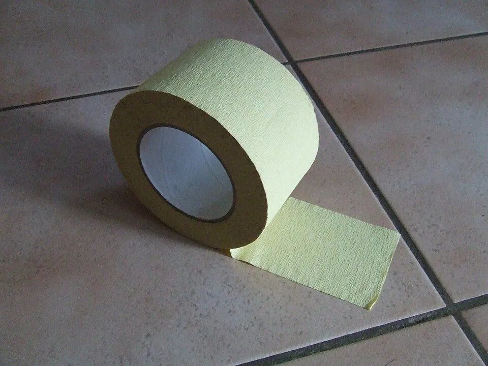 Rouleau de ruban de masquage en papier clair partiellement déroulé