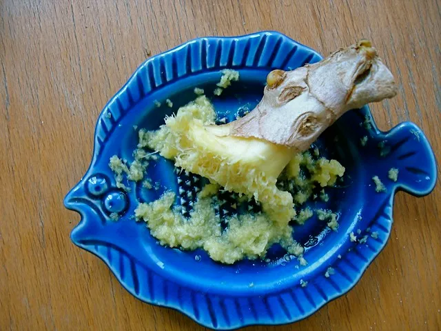 Petite râpe en céramique bleue garnie de gingembre râpé