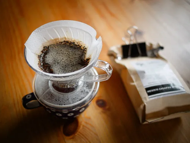 Hario V60 transparent en plastique pendant une préparation sur une table en bois