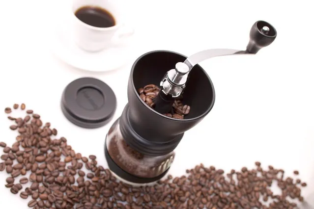 Moulin Hario Skerton ouvert, entouré de grains de café