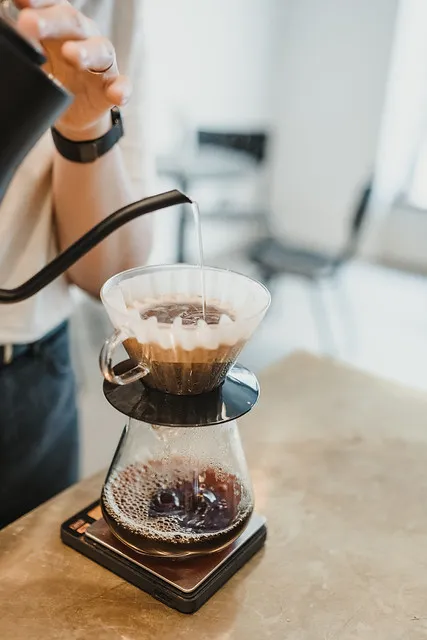 Versement d’eau dans un filtre papier posé dans un Hario V60