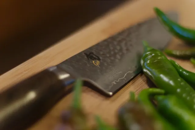 Couteau Shun près de poivrons sur une planche