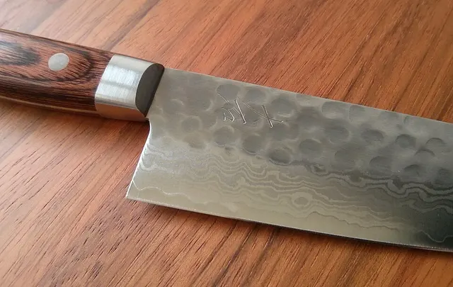 Détail d’une lame de gyuto Ohishi sur une planche
