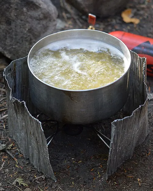 Cuisson de pâtes dans une popote lors d’une sortie en camping