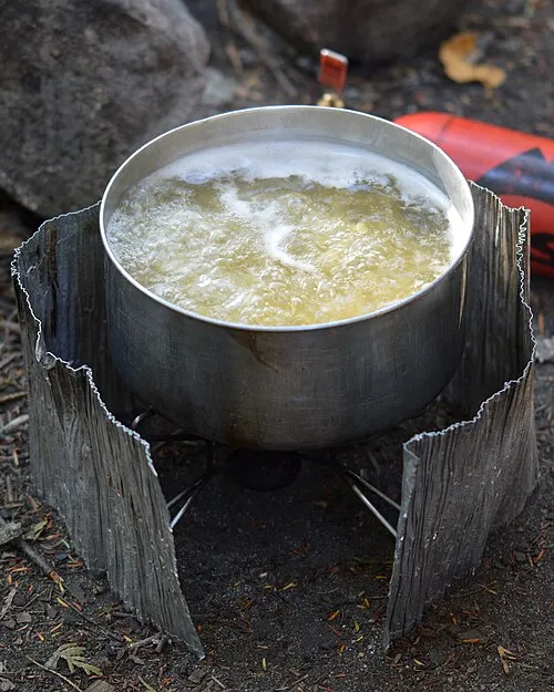 Cuisson de pâtes dans une popote lors d’une sortie en camping