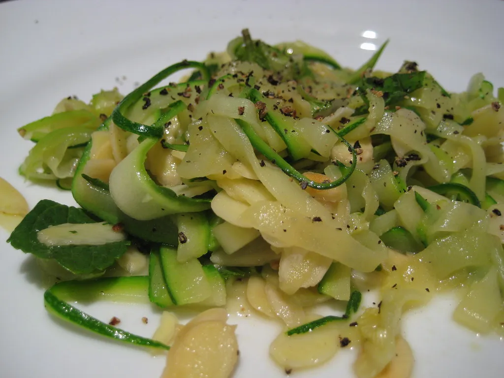 Zucchine tagliate a nastri e servite in un piatto.