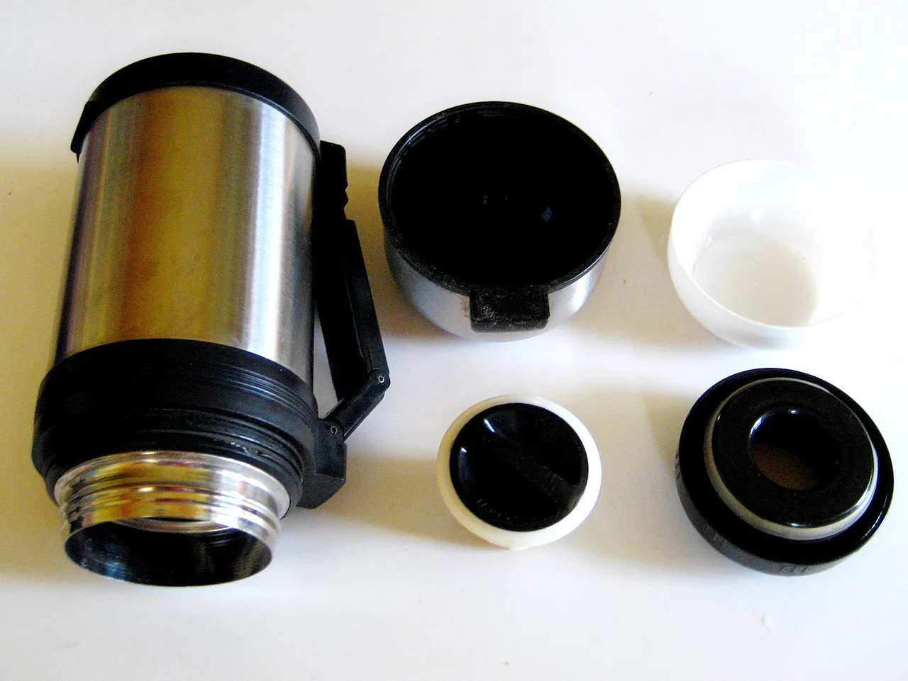 Thermos smontato con vari componenti del tappo.