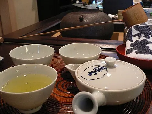 Teiera kyusu e piccole tazze con tè verde su un vassoio