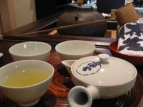 Teiera kyusu e piccole tazze con tè verde su un vassoio