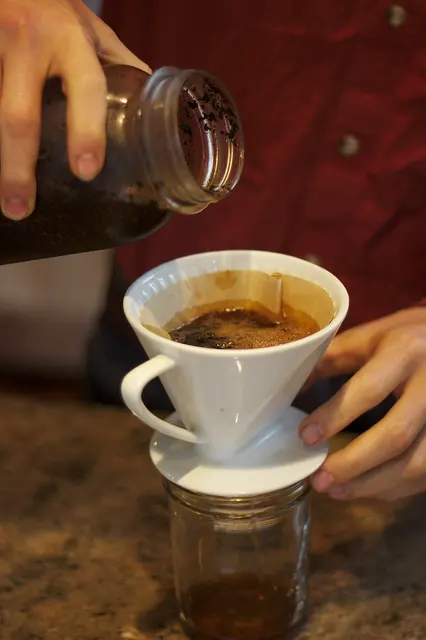 Caffè estratto a freddo versato da un barattolo attraverso un filtro di carta