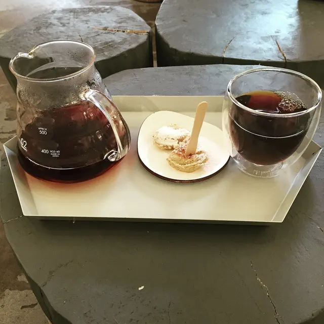 Caffè preparato con V60, servito in una caraffa di vetro accanto alla tazza