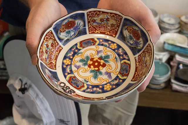Una ciotola di ceramica giapponese decorata, tenuta tra le mani
