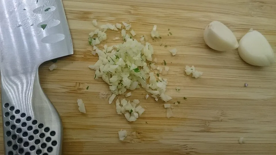 Aglio tritato su un tagliere di legno