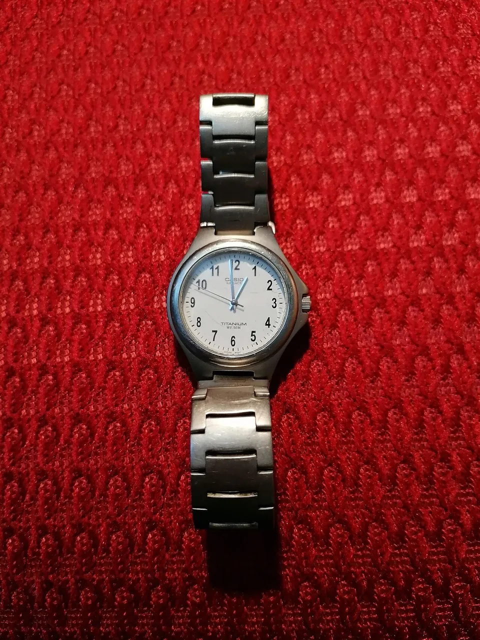 Casio Lineage in titanio con bracciale, appoggiato su tessuto rosso