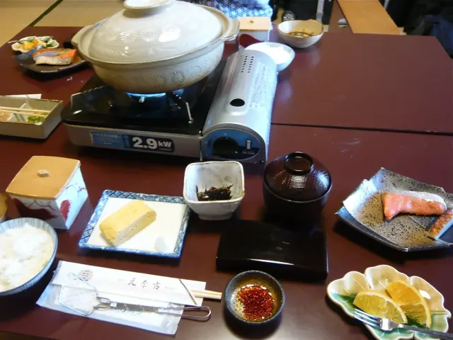Japanisches Frühstück mit verschiedenem Serviergeschirr und Donabe; allgemeines Anwendungsfoto.
