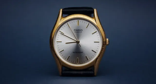 Analog Casio med ljus urtavla, mörka visare och enkla index.