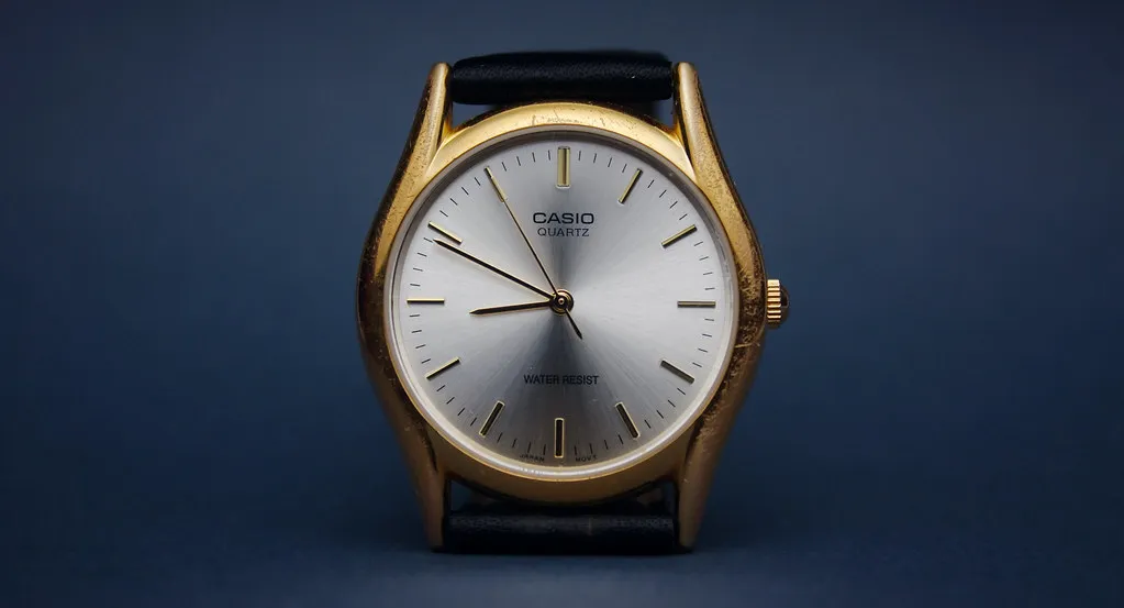 Analog Casio med ljus urtavla, mörka visare och enkla index.