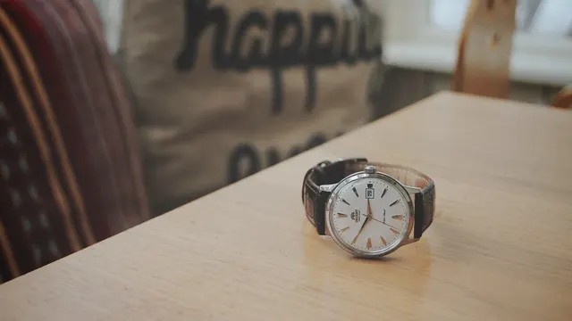 Orient Bambino med ljus urtavla och brunt läderband på ett bord.