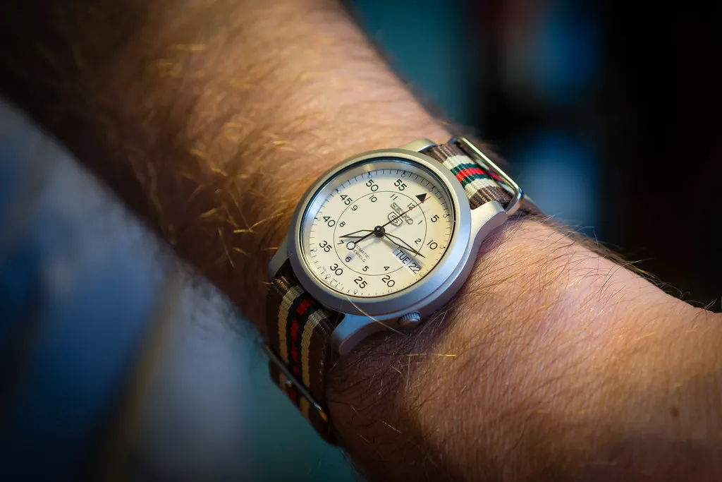 Ljus Seiko 5 på randigt NATO-band, buren på handleden.