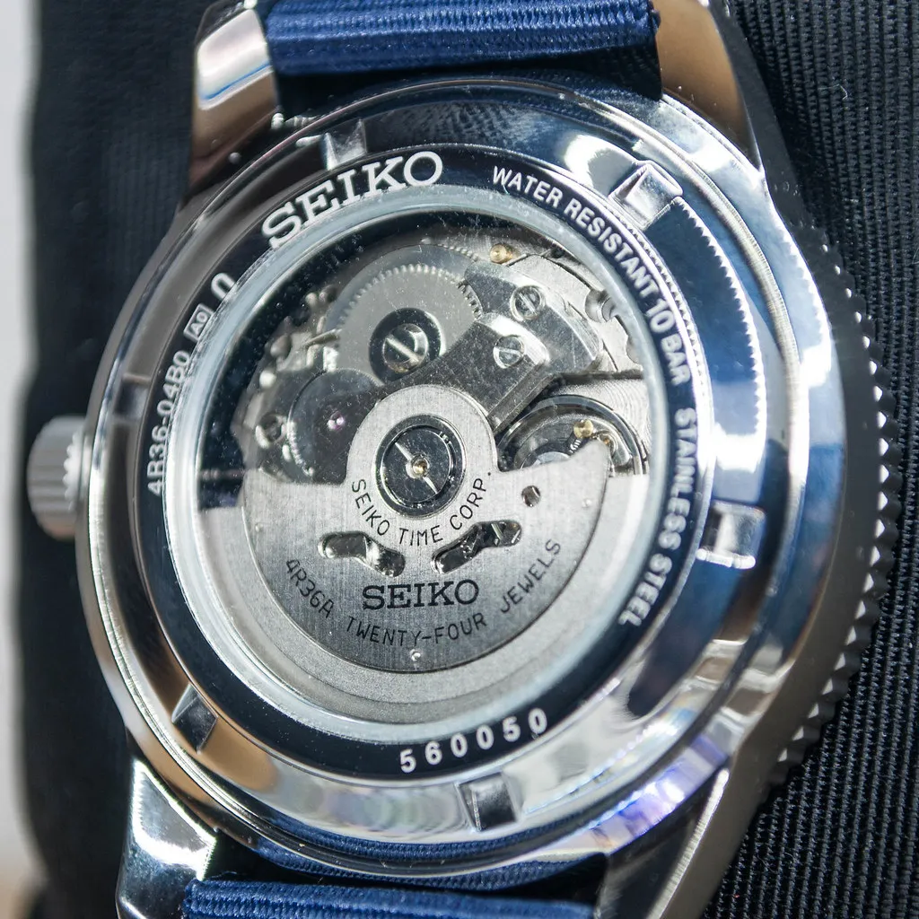 Synligt mekaniskt urverk genom baksidan på en Seiko SRP665.
