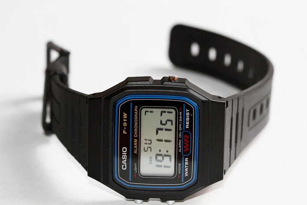 Svart Casio F-91W med blå ram runt displayen och öppet band.