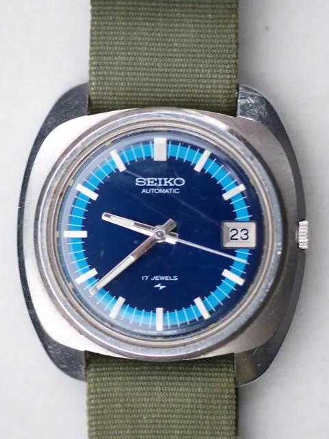 Äldre Seiko 7005-7080R med blå tavla och textilband mellan bandhornen.