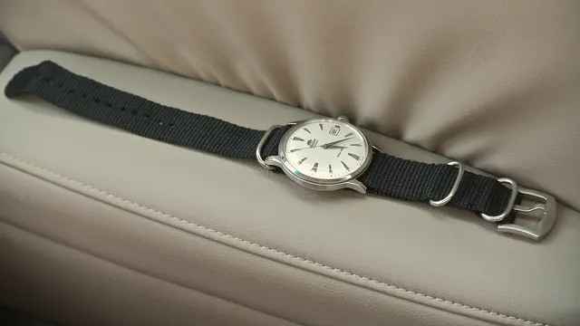 Orient Bambino med ljus urtavla på ett grått nylonband.
