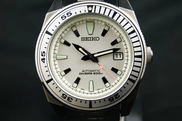 Seiko med ljus urtavla och mörka visare och index.