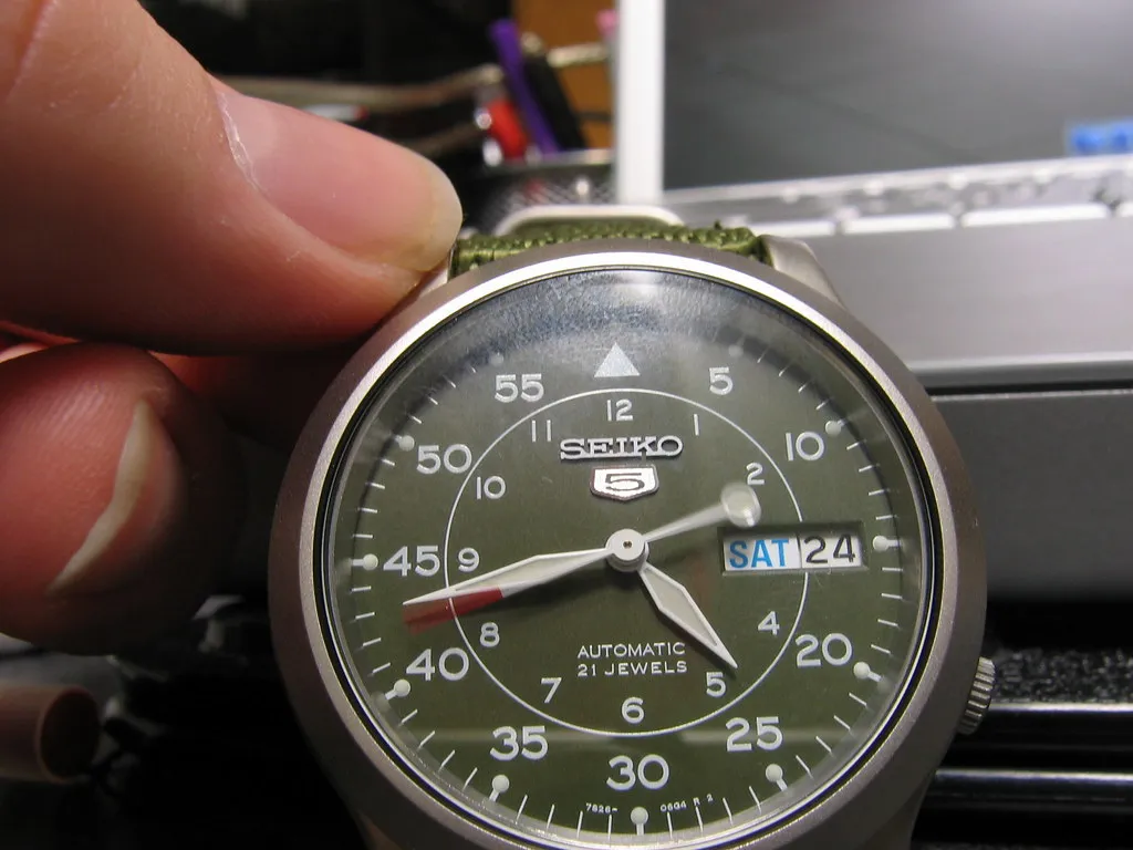 Seiko 5 med grön urtavla, fotograferad nära kronan.