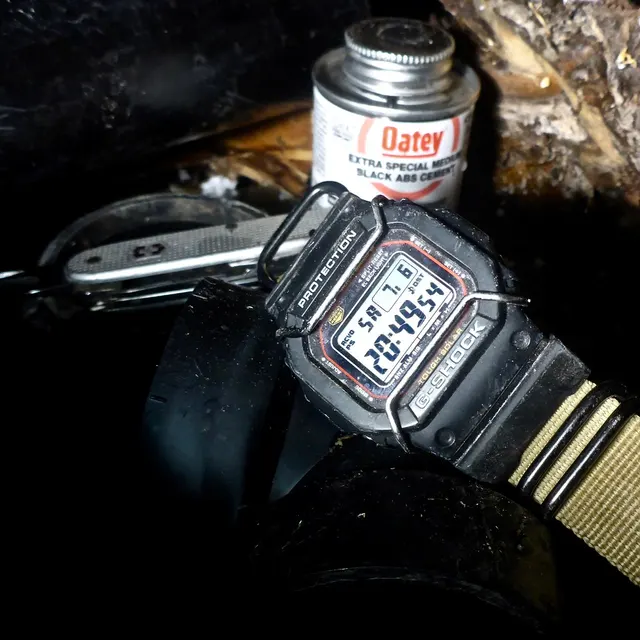 Äldre Casio G-Shock GW-M5610 med digital display i en arbetsmiljö.