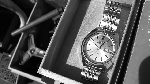 Äldre Seiko 5 med ljus urtavla och stållänk i en ask.