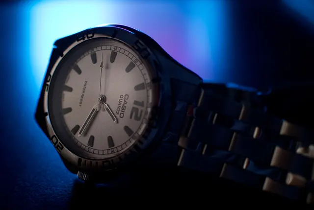 Analog Casio Edifice med ljus urtavla mot en blå bakgrund.