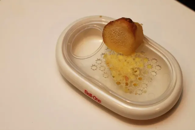 Ingefära och rivet fruktkött på ett litet keramiskt rivfat.