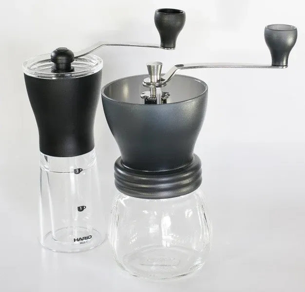 Två manuella Hario-kaffekvarnar, Mini Mill och Skerton, bredvid varandra.