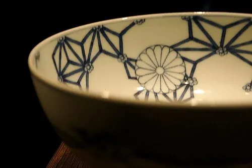 Dekorerad japansk skål med blått geometriskt mönster på insidan.